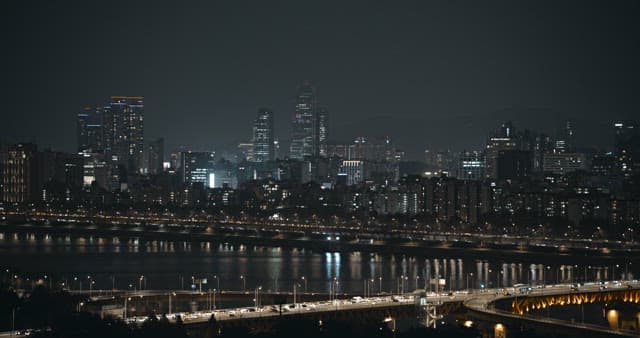 Nighttime View of Illuminated Cityscape and Bridge