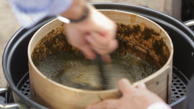 Stirring seaweed jelly batter with a wooden spatula in a bowl