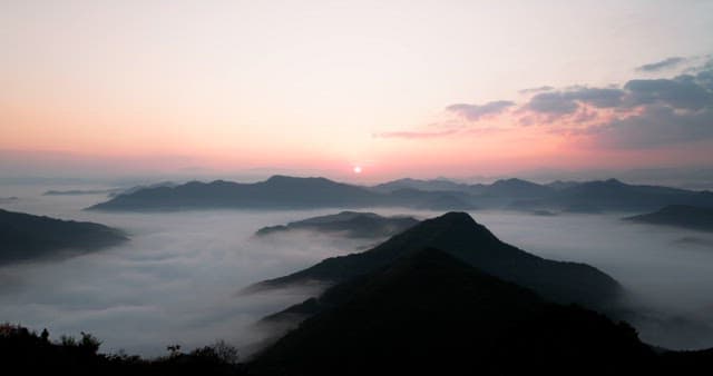 Sky Colored by Sunrise over Foggy Mountains