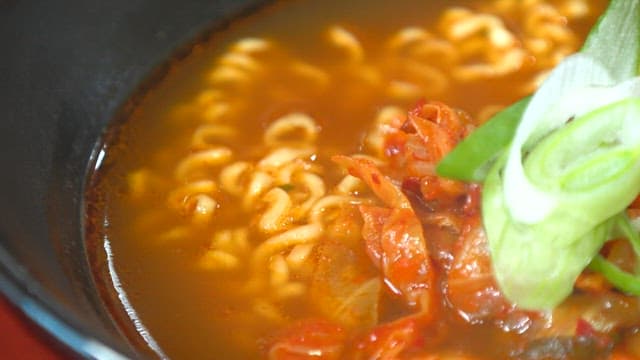 Bowl of spicy ramen topped with green onions