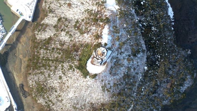 Snow-covered observation tower overlooking a seaside town