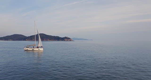 Yacht sailing near a coastal town