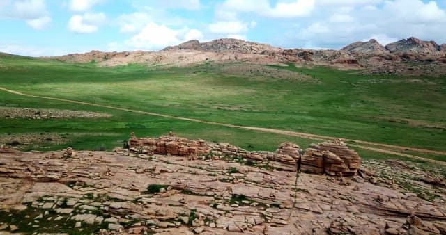 Vast green plains with rocky hills