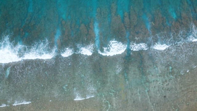Waves Gently Rolling in Shallow Sea Full of Coral Reefs
