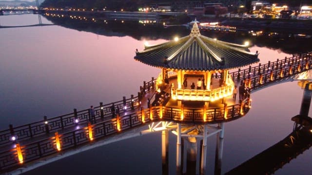 Illuminated pavilion on a serene river at night