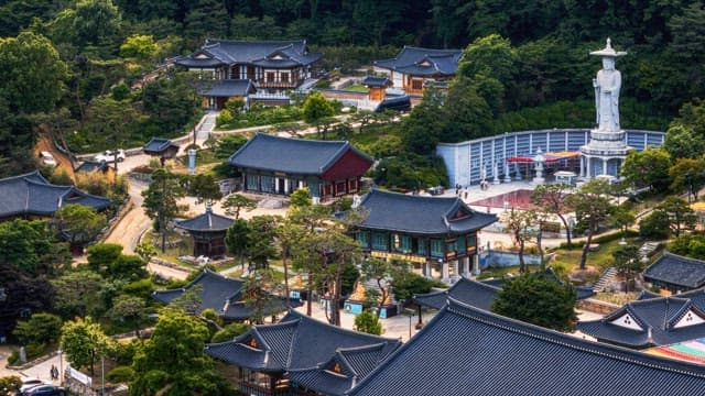 View of a Buddhist temple complex surrounded by lush greenery