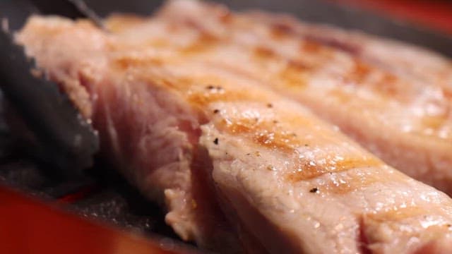 Juicy pork belly sizzling on a hot grill