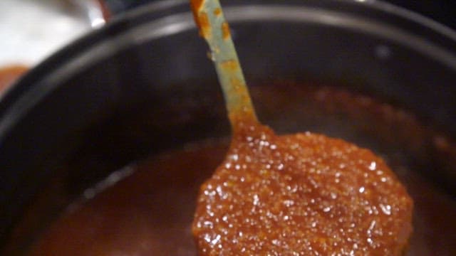 Rich sauce for pork cutlet being stirred in a pot