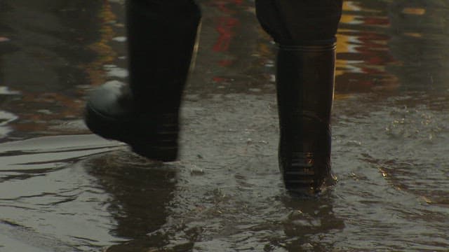 Merchant Walking on the Floor of a Fish Market Splashed with Sea Water