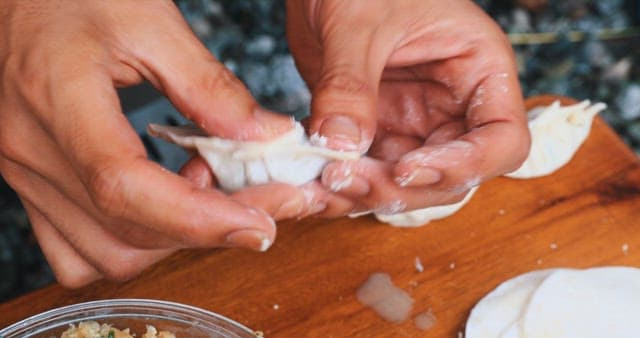 Preparing Dumplings by Hand on a Wooden Board