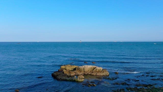 Serene blue sea with reefs and horizon visible under a clear sky