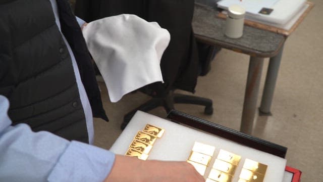 Person polishing gold bars on a table