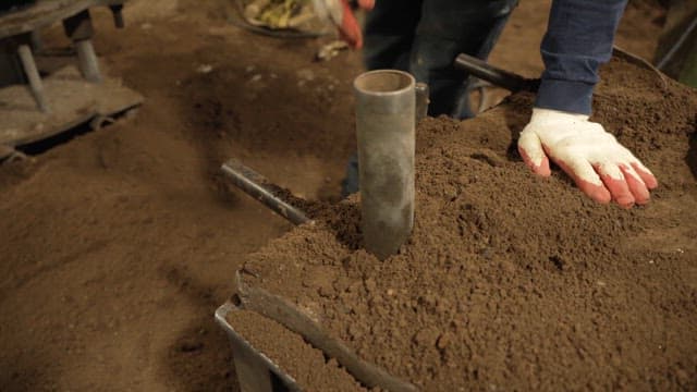 Worker shaping sand mold in a factory