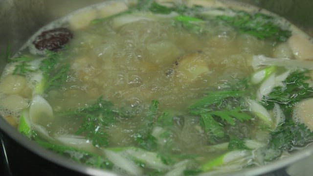 Soup with various vegetables and abalone is boiling briskly