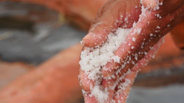 Hands Grasping White Salt Crystals