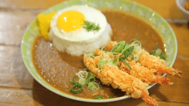 Fried shrimp curry rice with egg on a plate