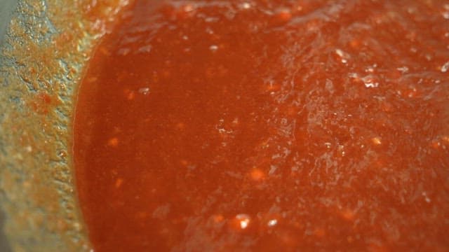 Red sauce made by stirring with a ladle in a bowl
