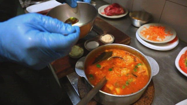 Seasoning a hearty stew in a restaurant kitchen