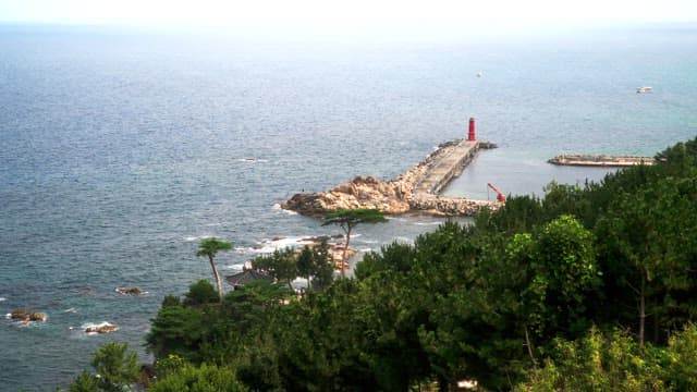 Lighthouse on a rocky pier by the sea