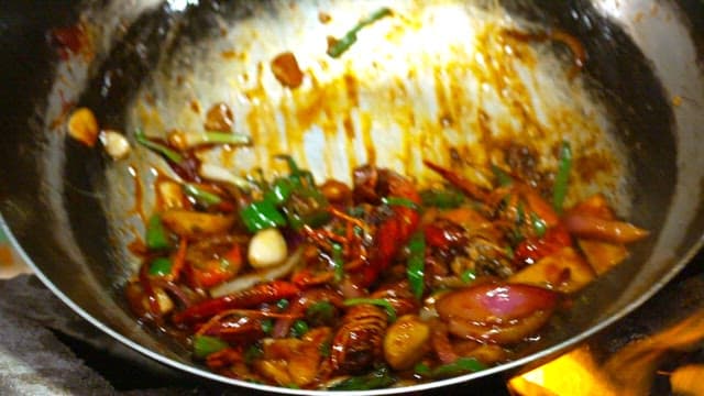 Mala long xia being cooked in a pan with flames