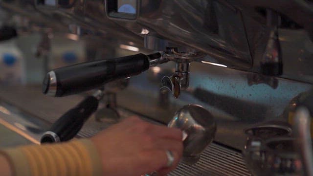 Barista Crafting Espresso in Coffee Machine