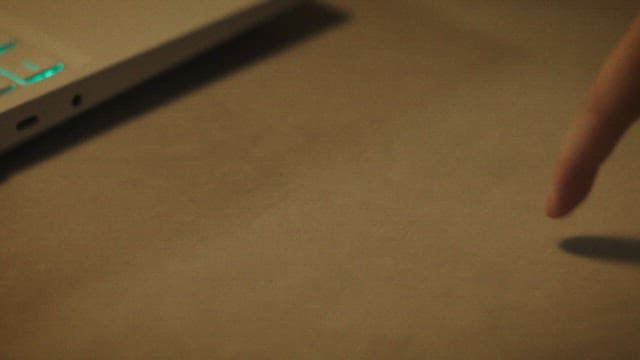 Fingers playfully pressing the laptop keyboard on the table