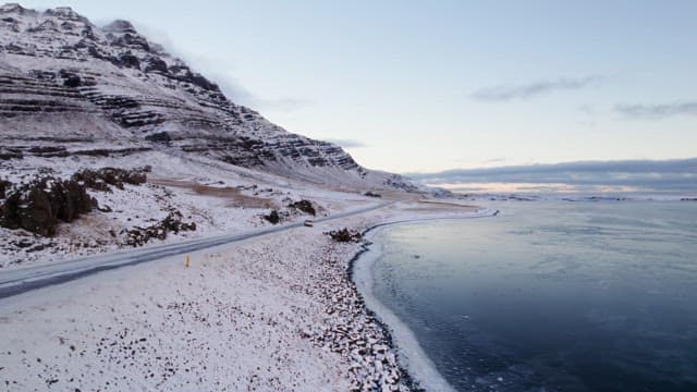 Car driving on a snowy coastal road
