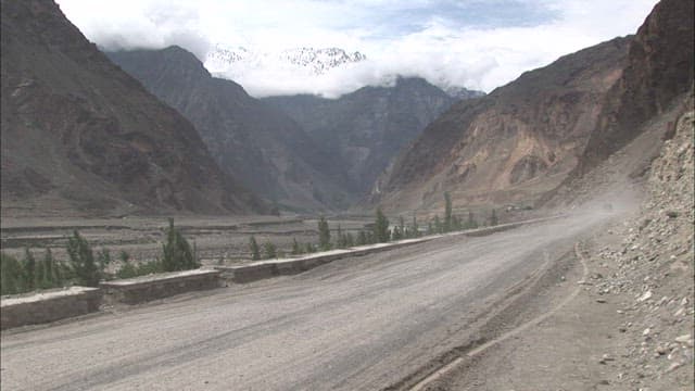 Dusty Mountain Road with Passing Bus