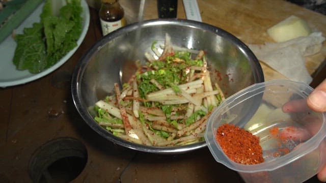 Mixing vegetables with red pepper flakes