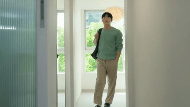 Man carrying a bag and walking through house with bright interior