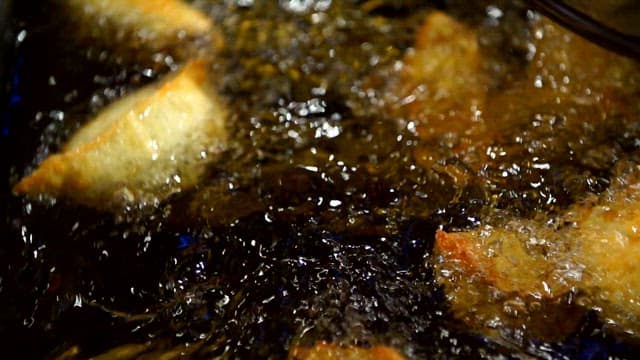 Close-up View of Frying Dumplings in Oil