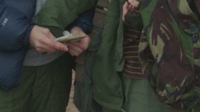 Two people exchanging money outdoors.