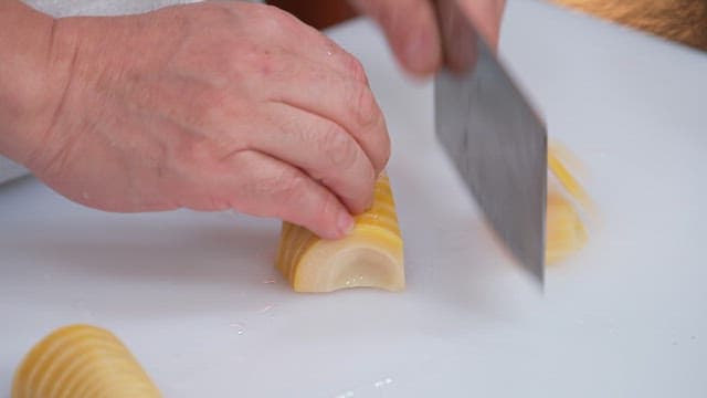 Slicing bamboo shoots on a cutting board