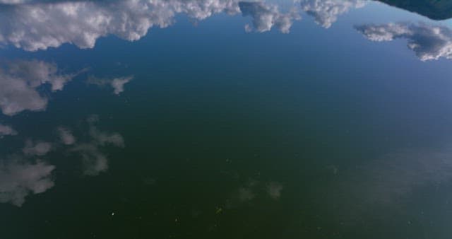 Serene lake reflecting the sky and mountains
