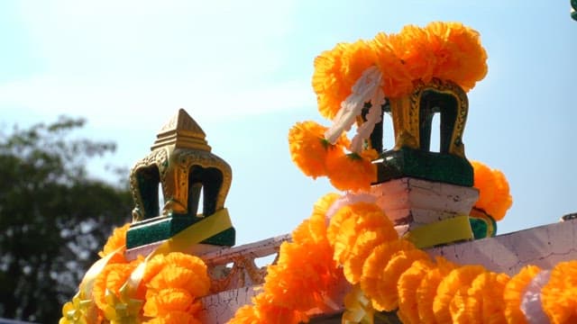 Ornate roof of shrine adorned with vibrant marigold garlands