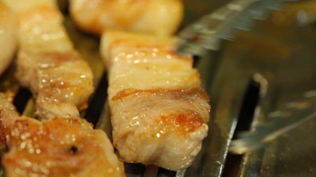 Grilled pork belly sizzling on a grill