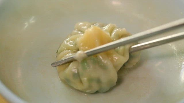 Picking up dumplings in the bowl with chopsticks