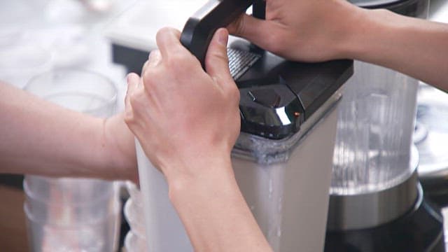 Pouring the Grinded Potato Shake from the Blender into a Glass Bowl