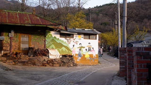 Quaint alley with a traditional mural on a rustic house