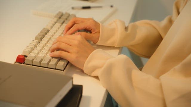 Woman using a keyboard at a desk in a calmly lit room