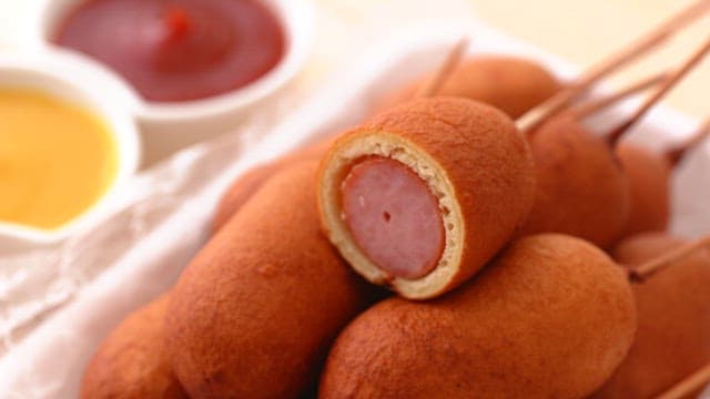 Scene of picking up a hot dog with cross section visible