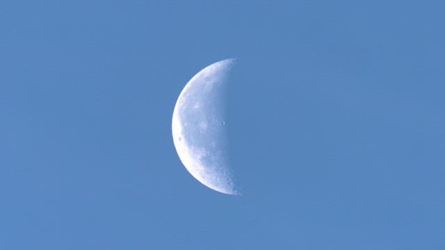 Crescent moon gradually becoming obscured during the day