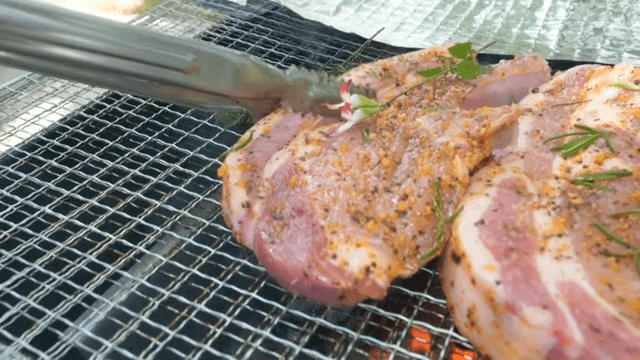 Juicy seasoned steaks grilling over charcoal flames
