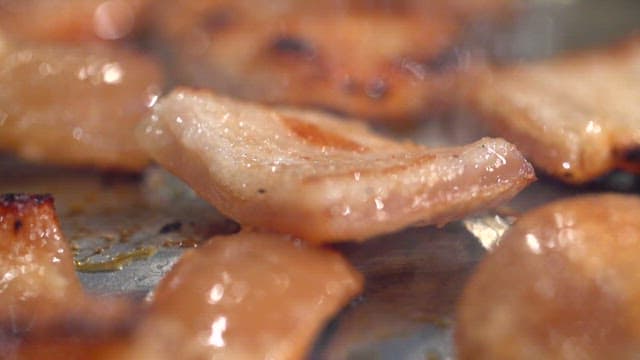 Grilled pork rinds being cooked on a grill