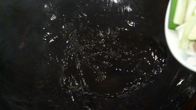 Vegetables being added to a hot wok