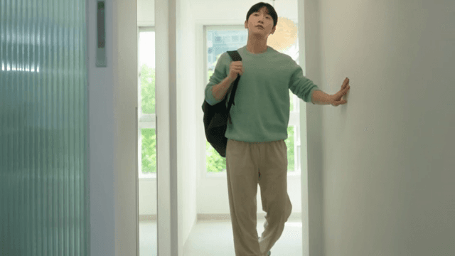Man carrying a bag and walking through house with bright interior