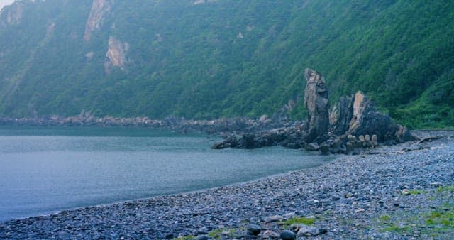 Serene Rocky Coastline with Green Hills
