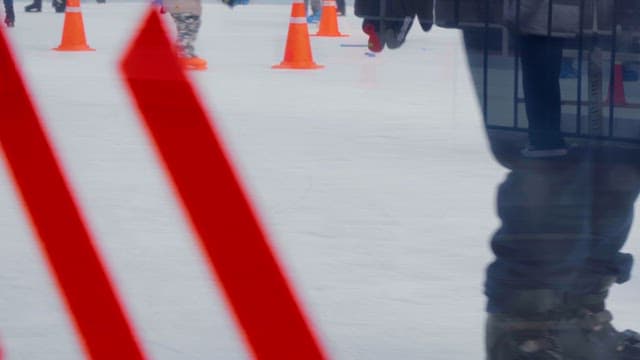 People ice skating on a rink with cones