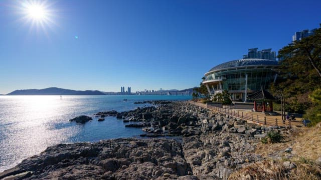 Sky from day to night as seen from a rocky shore with an observation deck