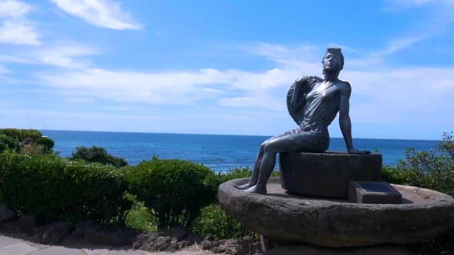 Statue of a Figure Against a Blue Sea